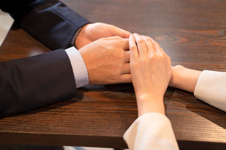 A lover couple holding hands at a cafeの写真素材