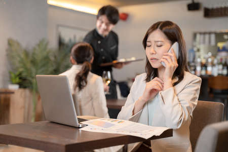 Female doing remote work at a restaurantの写真素材