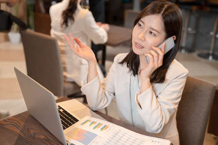 Female doing remote work at a restaurantの写真素材