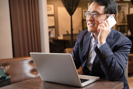 Male businessman doing remote work at a cafeの写真素材