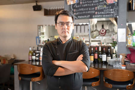 A man who runs a restaurant with his arms foldedの写真素材