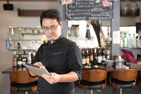 Male staff operating a tablet at a restaurant