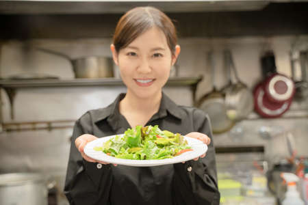Female staff serving food at the restaurantの写真素材