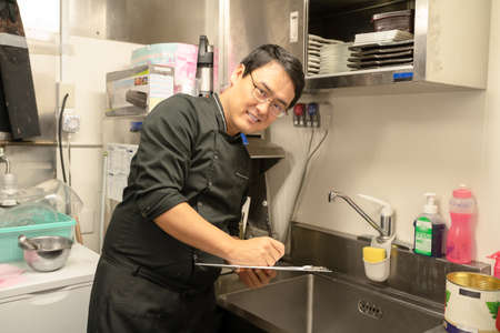 Male staff checking food hygiene managementの写真素材