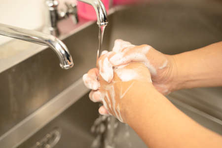 Hands of male staff washing hands in the sink of a restaurantの写真素材