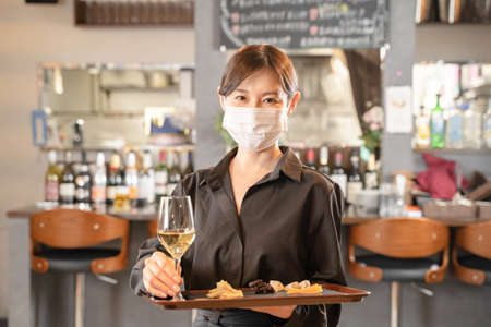 Female staff and male customers who provide meals against infectious diseases with masksの写真素材