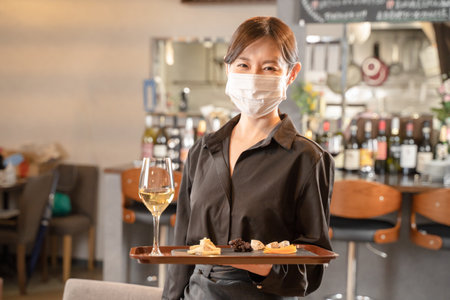 Female staff and male customers who provide meals against infectious diseases with masksの写真素材