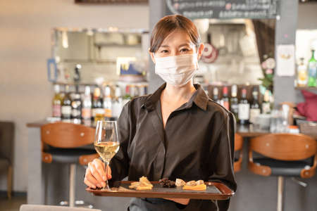 Female staff and male customers who provide meals against infectious diseases with masksの写真素材