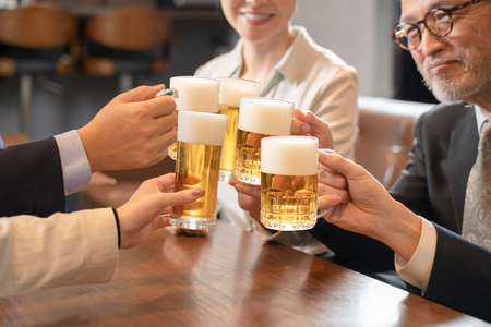 A launch party on the way home from work to toast with beerの写真素材