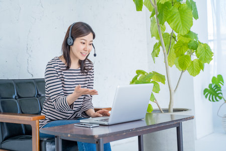Young asian woman using laptop computer at home, lifestyle concept.の写真素材