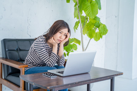 Young asian woman working on laptop computer in coffee shop, stock photoの写真素材