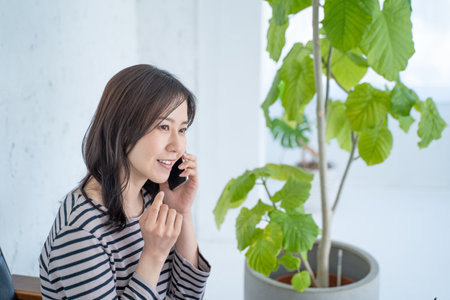 Portrait of a young businesswoman talking on mobile phone in officeの写真素材
