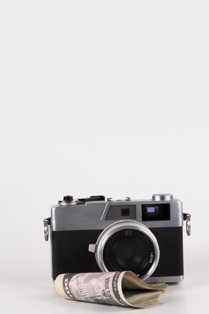 Camera with a dollar, model on dollar banknote, concept and idea of time value and money, realestate business and finance concepts. retro, green with the hands at 12 am or pmの写真素材