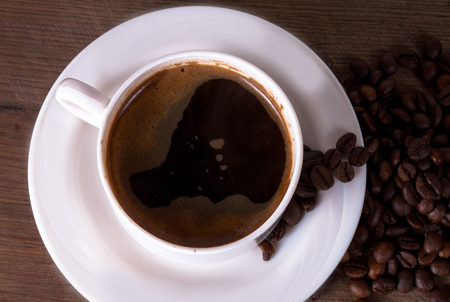 Coffee cup and beans on old kitchen table. Top view with copyspace for your textの写真素材