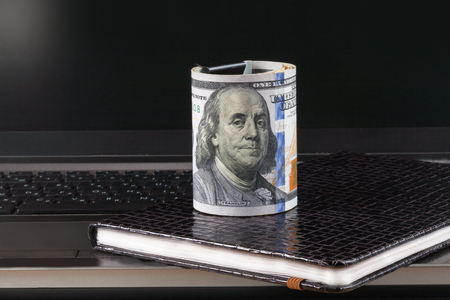 Laptop and notebook,dollars banknote, concept and idea of time value and money, realestate business and finance concepts. retro, green with the handsの写真素材