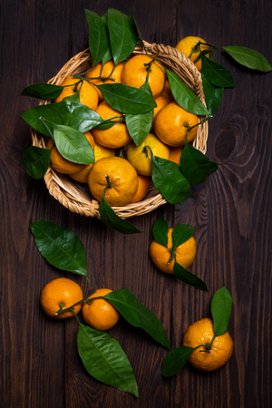 Tangerines in a basket on a wooden backgroundの写真素材