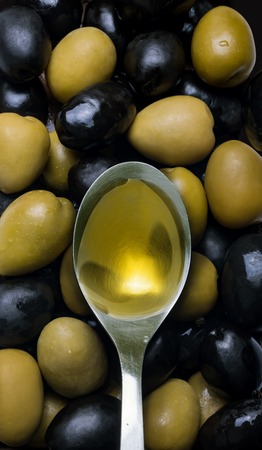 Black and green olives mix with spoonの写真素材