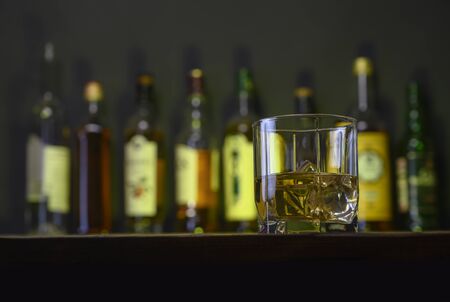 whiskey with ice stands on a bar counterの写真素材