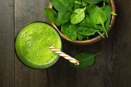 spinach smoothies in glass is on tableの写真素材