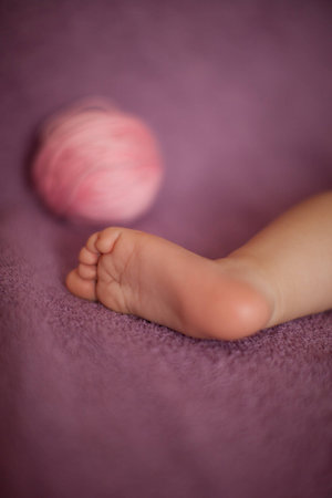 Baby s foot with ball of yarnの写真素材