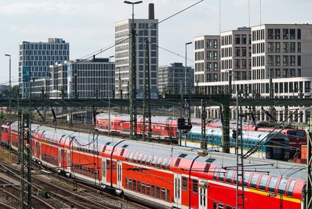 many trains in the railway station with houses in the backgroundの写真素材