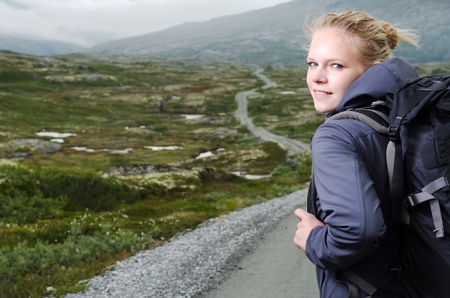 young blond woman hiking with scenery in the backgroundの写真素材