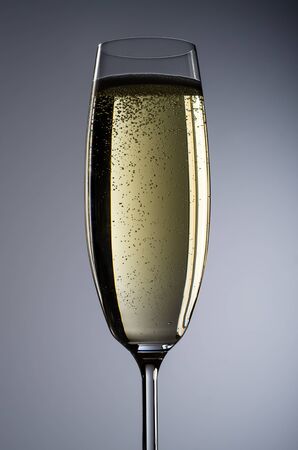 a full champagne glass before grey backgroundの写真素材