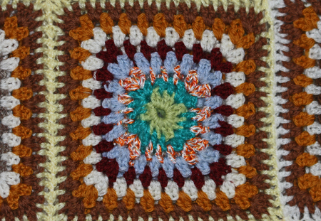 brightly coloured crocheted panel in a homemade woollen blanket with a mosaic designの写真素材