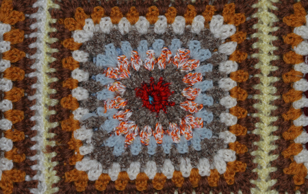 brightly coloured crocheted panel in a homemade woollen blanket with a mosaic designの写真素材