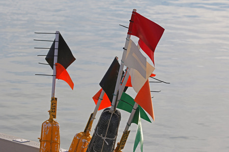 clam fishing marker flags on a fishing boat on the Adriatic Sea in the port or harbour of Numana near Ancona in Italy at Christmasの写真素材