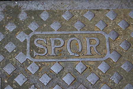 Latin SPQR on a manhole or drain cover in the streets of Rome, Italy, standing for the Latin SenatusQue Populus Romanusの写真素材
