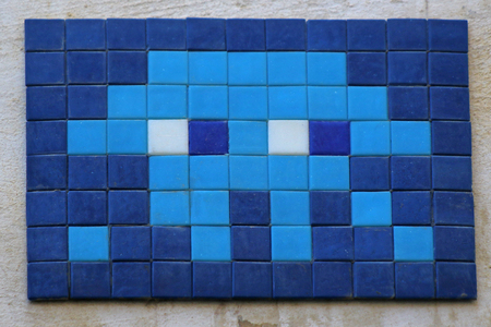 brightly coloured mosaic panel on a wall in Rome the Eternal City near the Trevi fountain a famous Baroque landmark with an Invader or space invader mosaic designの写真素材