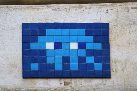brightly coloured mosaic panel on a wall in Rome the Eternal City near the Trevi fountain a famous Baroque landmark with an Invader or space invader mosaic designの写真素材