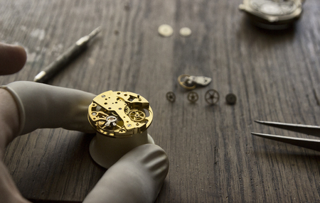 A watch maker is repairing a vintage automatic watch.