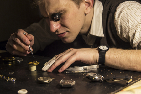 The watchmaker is repairing the mechanical watches in his workshopの写真素材