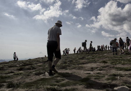 Sad man climbs uphill with his head down