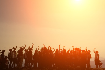 Funny people with their hands up, fun, sunsetの写真素材
