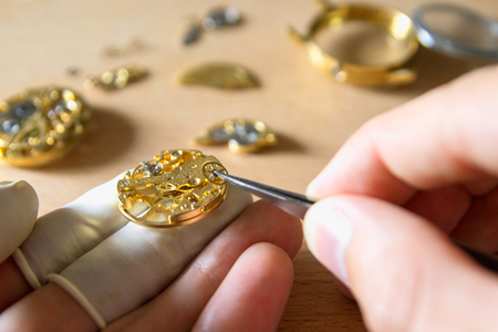 Watchmaker is repairing the mechanical watches in his workshopの写真素材