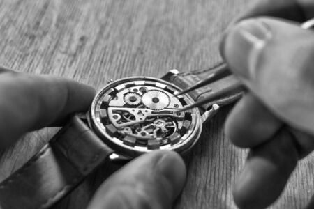 Watchmaker is repairing the mechanical watches in his workshopの写真素材