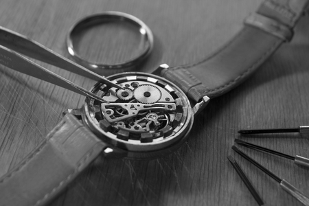 Watchmaker is repairing the mechanical watches in his workshopの写真素材