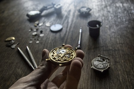 A watch maker is repairing a vintage automatic watch.の写真素材