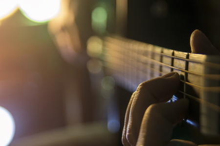 Man with guitar, male hand playing on acoustic guitar. Close-up.の写真素材