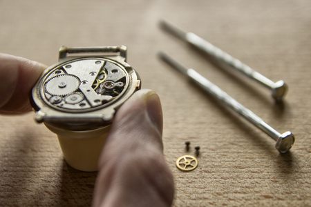 Watchmaker is repairing the mechanical watches in his workshopの写真素材