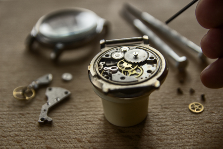 Watchmaker is repairing the mechanical watches in his workshopの写真素材