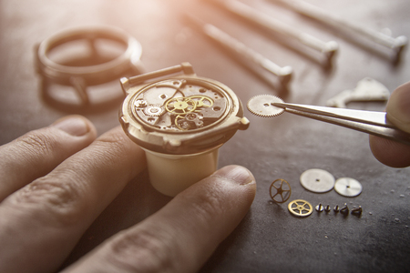Watchmaker is repairing the mechanical watches in his workshopの写真素材