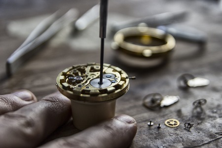 Watchmaker is repairing the mechanical watches in his workshopの写真素材