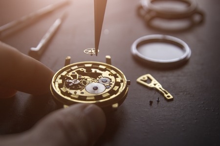 Watchmaker is repairing the mechanical watches in his workshopの写真素材