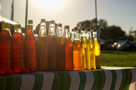 A lot of coloured beverages, sunlight, red, yellow, greenの写真素材