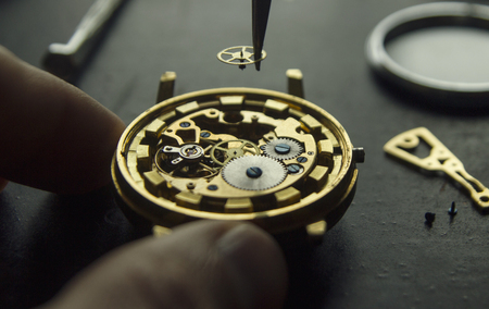 Watchmaker is repairing the mechanical watches in his workshopの写真素材