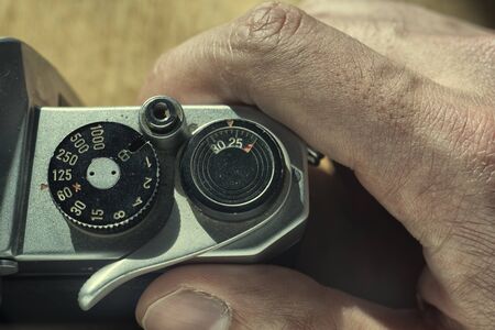 Setting the shutter speed on an analog camera, man's handの写真素材